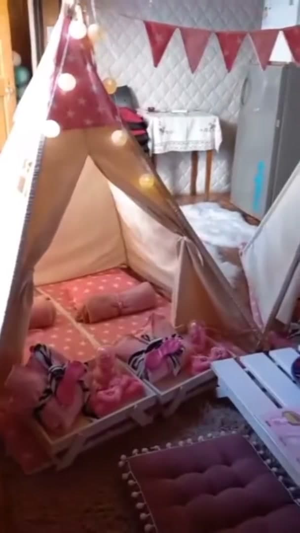 Carpa tipi blanca con banderines rosados, luces cálidas y colchonetas con cojines y antifaces